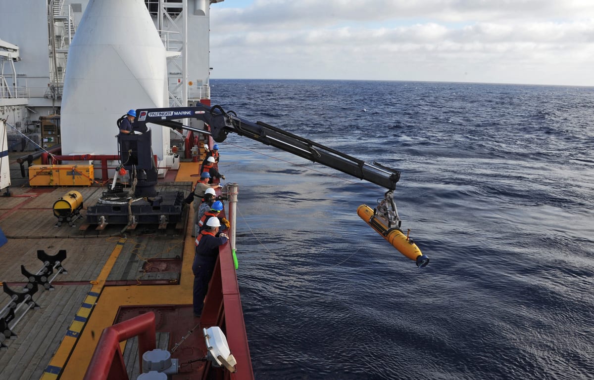 Bluefin-21 autonomous underwater vehicle suspended beside Ocean Shield during deployment preparations