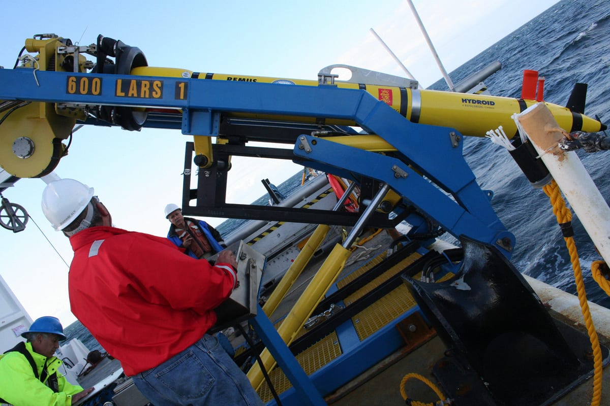 Naval Oceanographic Office surveyors preparing a REMUS 600 autonomous underwater vehicle for launch